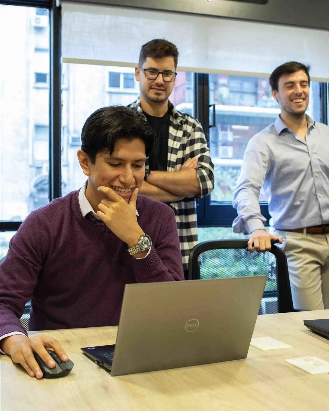 Tres personas del equipo revisando una solución en una notebook